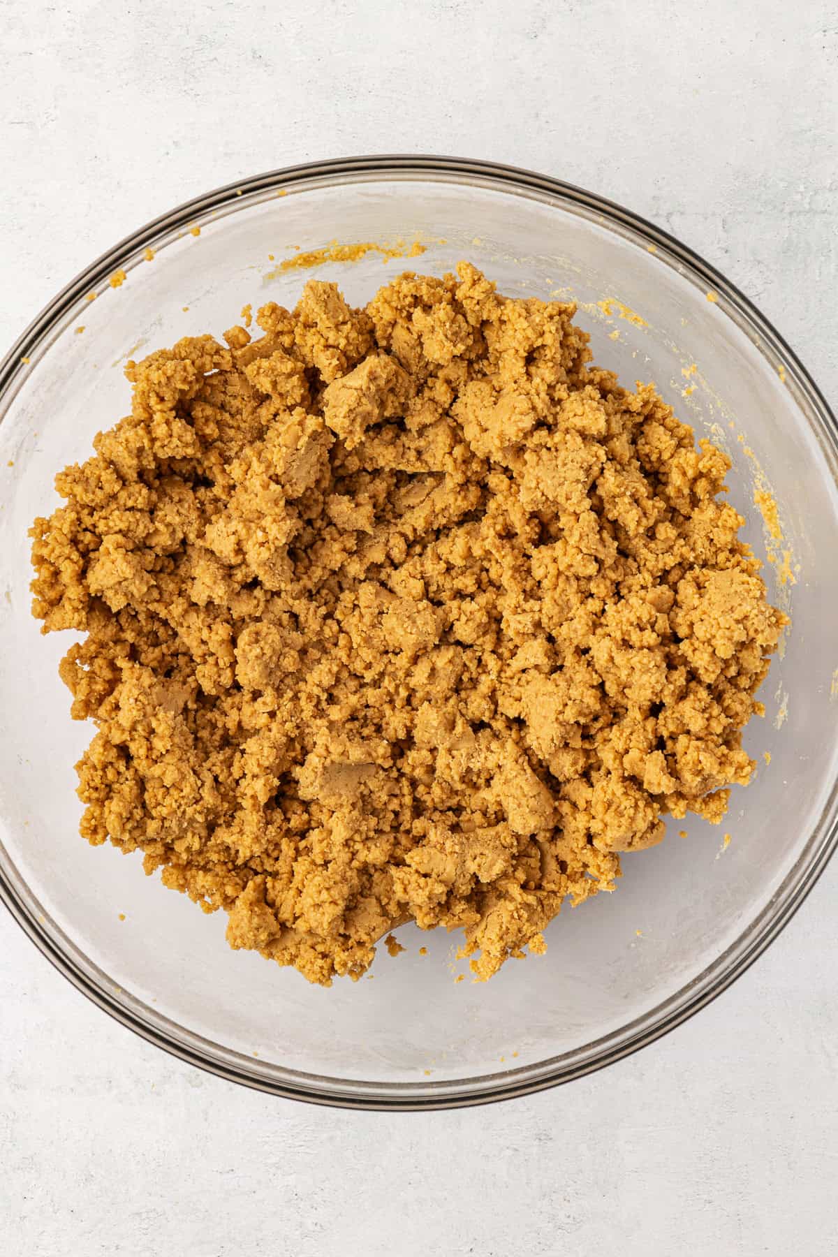 a peanut butter and graham cracker mixture for peanut butter bars in a clear glass bowl