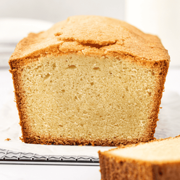 pound cake with one slice cut off the end laying beside it, exposing the light center with the golden brown outer edge