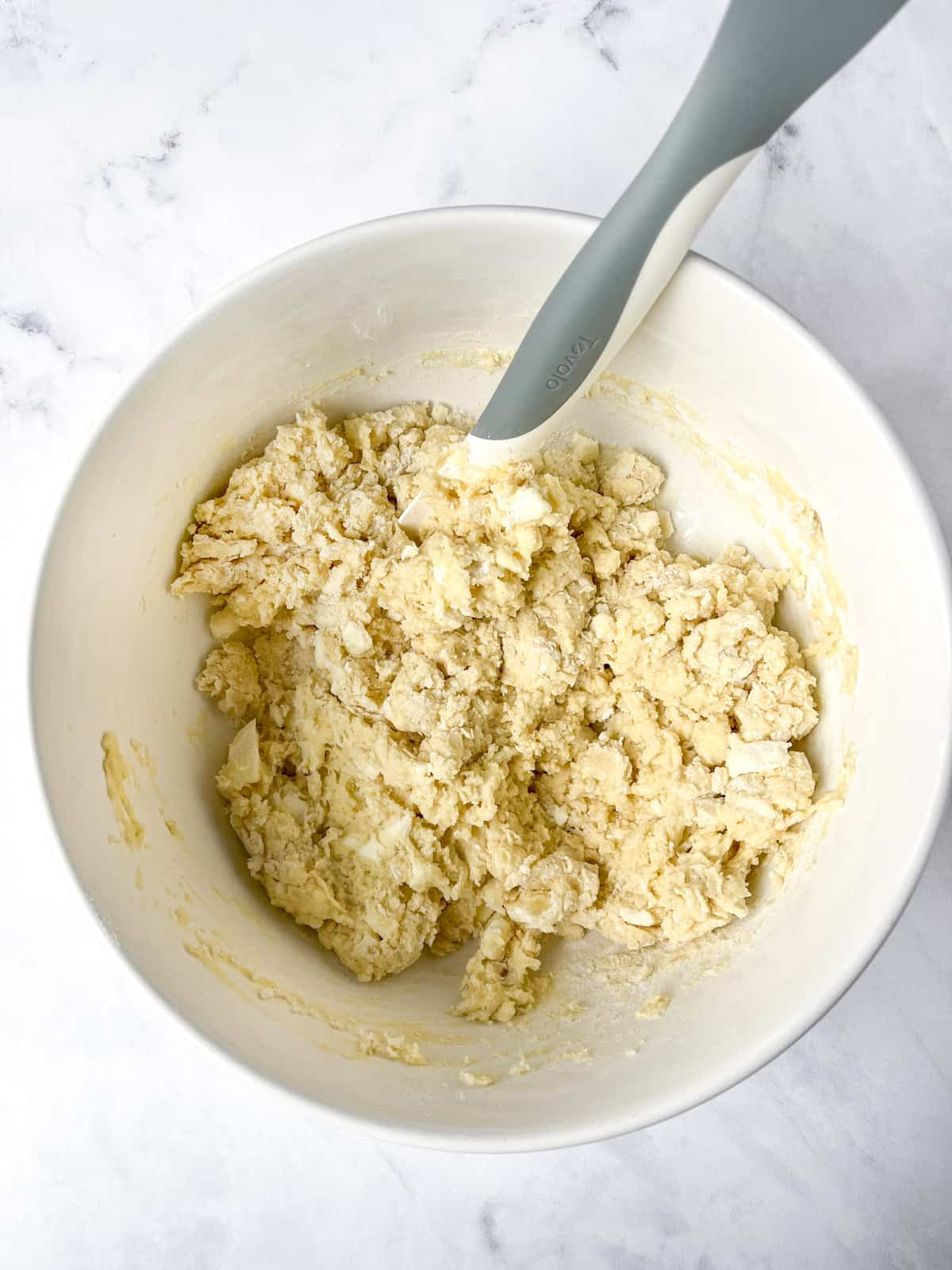 scone dough mixed together in a white bowl with a spatula