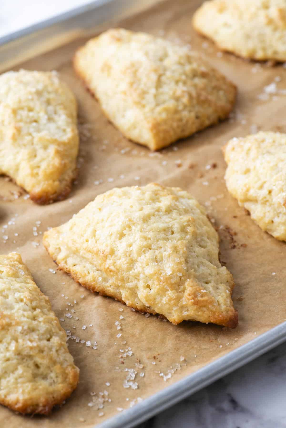 plain scones on a baking sheet lined with parchment paper with coarse salt sprinkled around