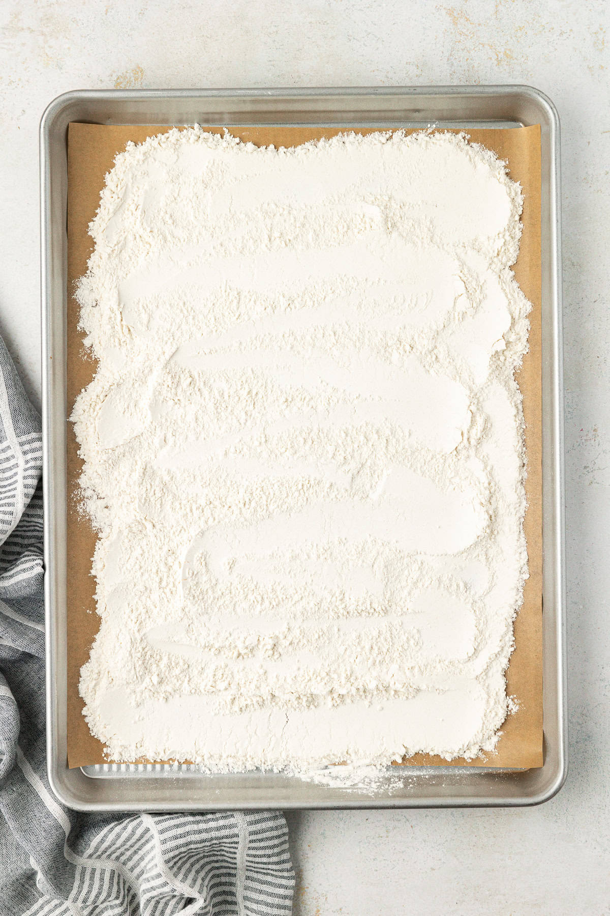 a baking sheet lined with parchment paper with all-purpose flour spread out all over it