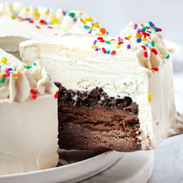 a slice of ice cream cake being lifted away from the rest of the cake with a spatula