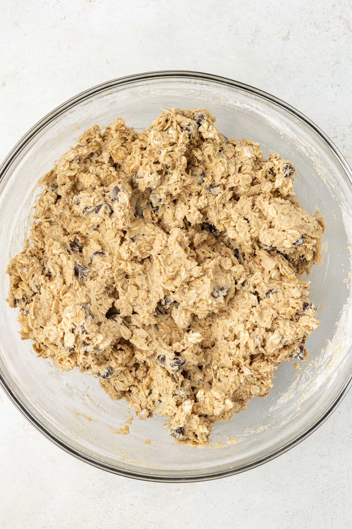 oatmeal chocolate chip cookie dough mixed together in a clear glass bowl