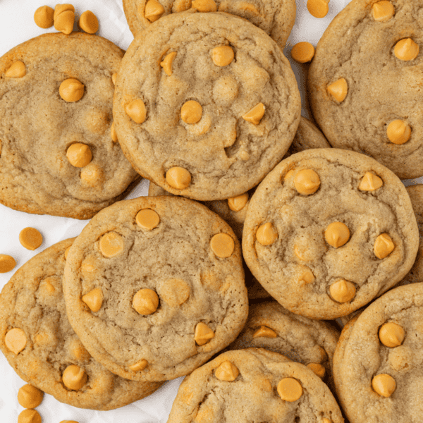 a pile of butterscotch cookies with butterscotch chips scattered around