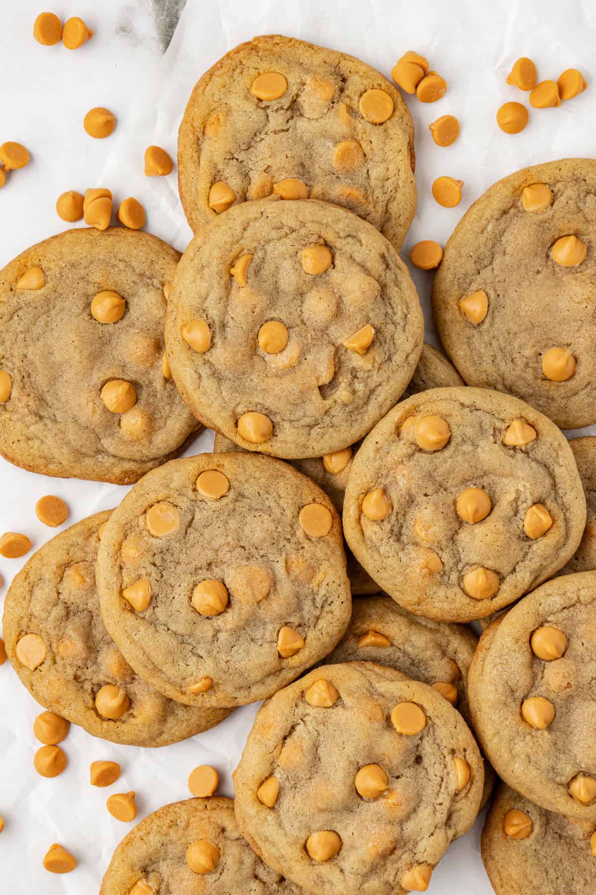 over head view of a pile of butter scotch cookies with butterscotch chips sprinkled around