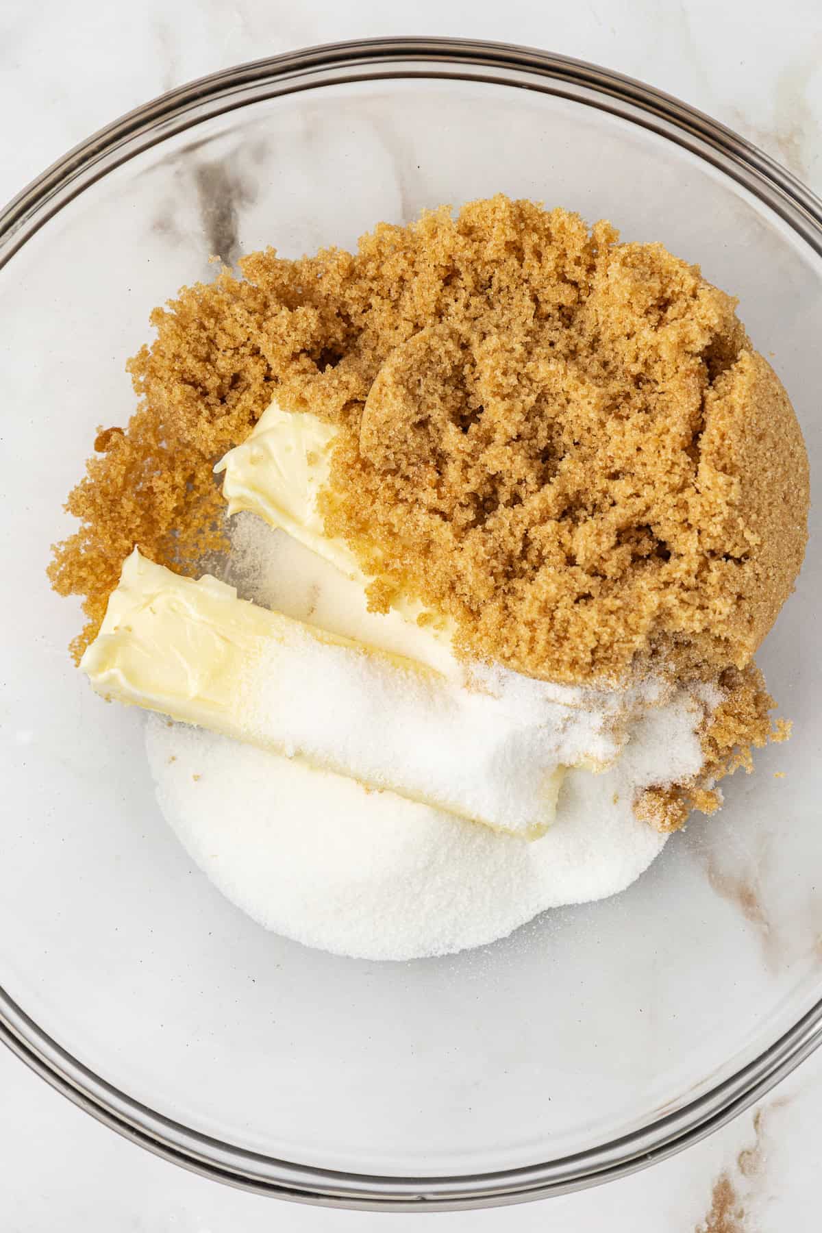 butter, brown sugar and white sugar in a clear glass bowl