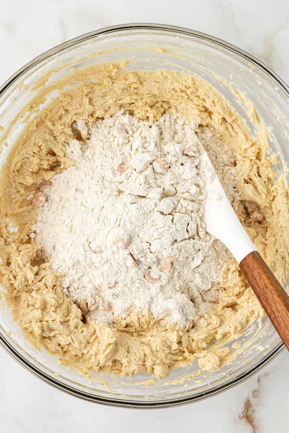 wet ingredients for butterscotch cookies in a clear glass bowl with a pile of dry ingredients on top