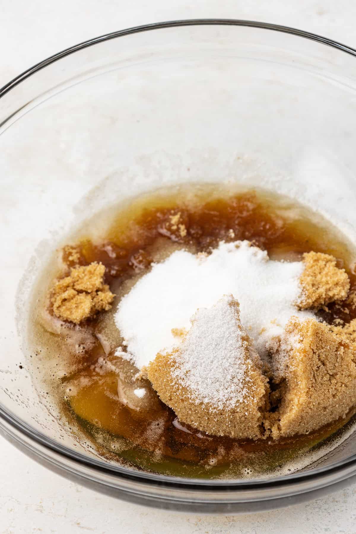 granulated sugar, brown sugar and eggs in a clear glass mixing bowl