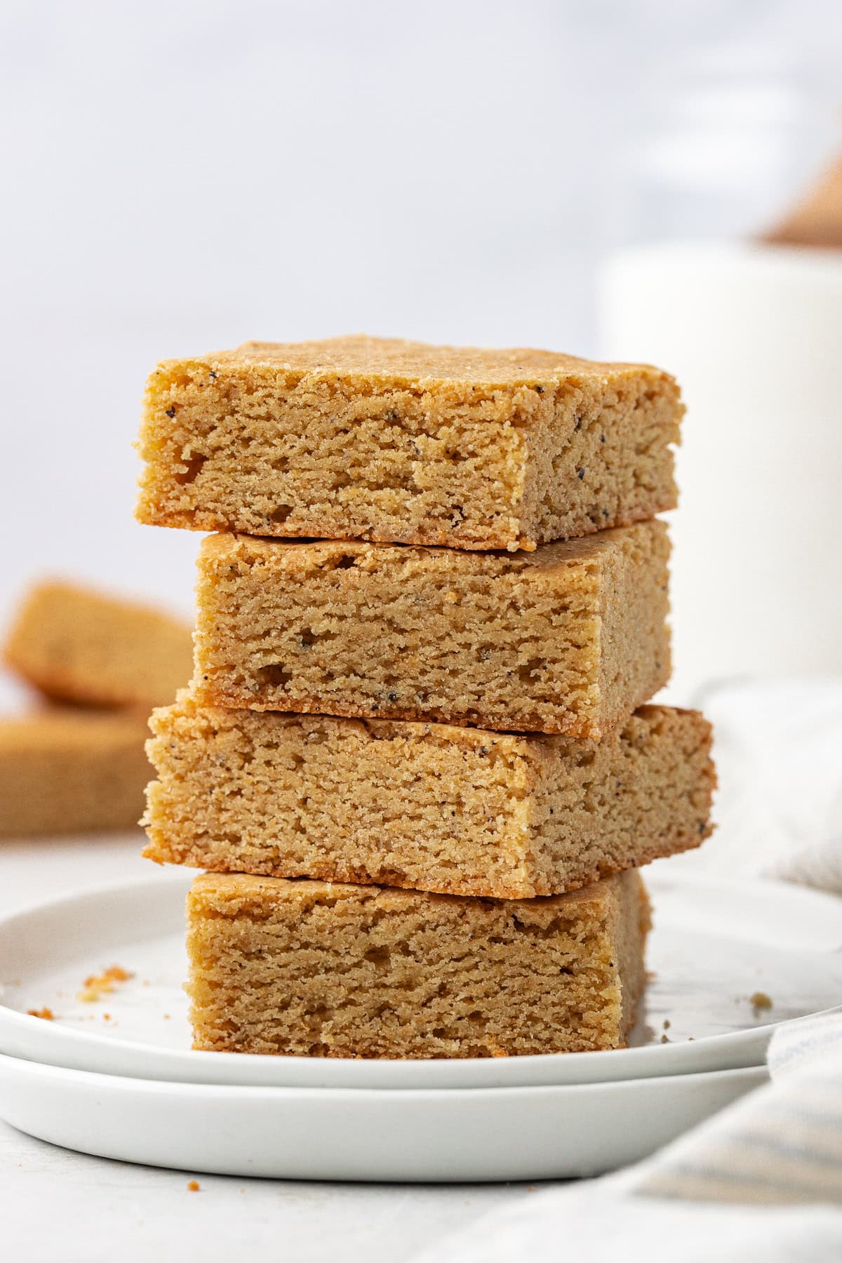 a stack of four blondies on a stack of two small white plates