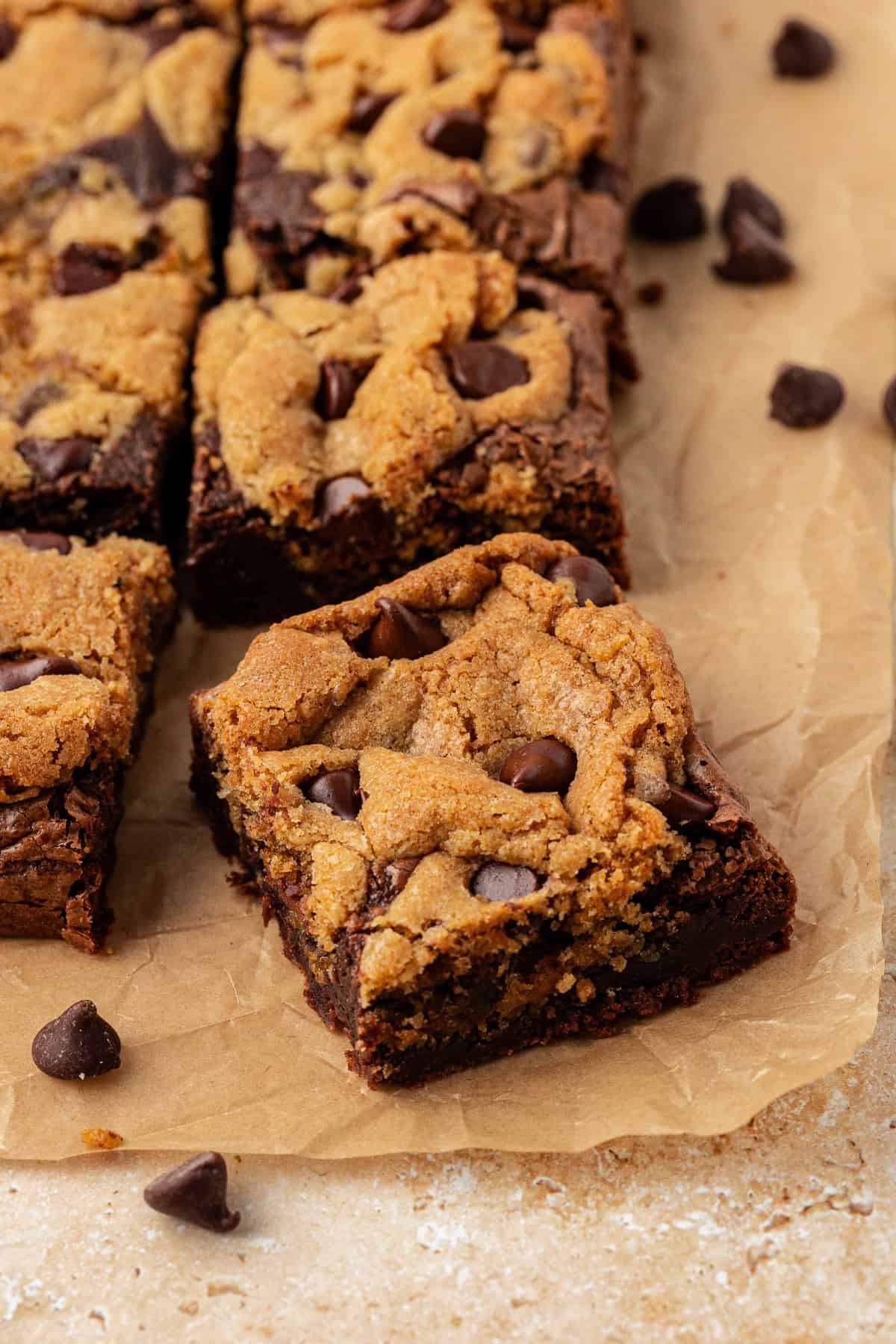 rows of brookies on brown parchment paper with chocolate chips scattered around