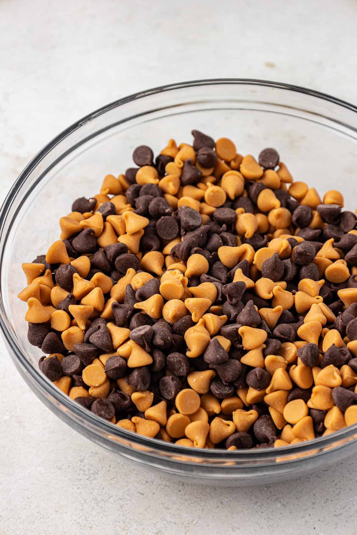 butterscotch chips and chocolate chips in a clear glass bowl