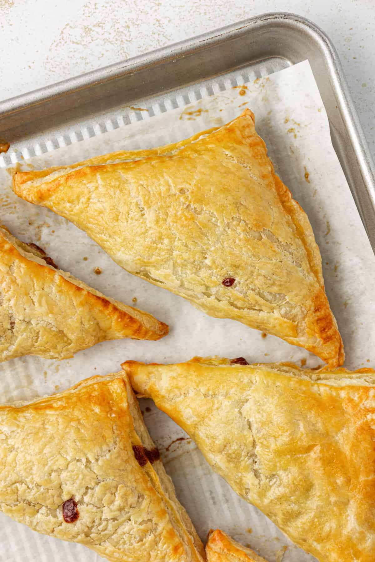 apple turnovers on a baking sheet lined with parchment paper