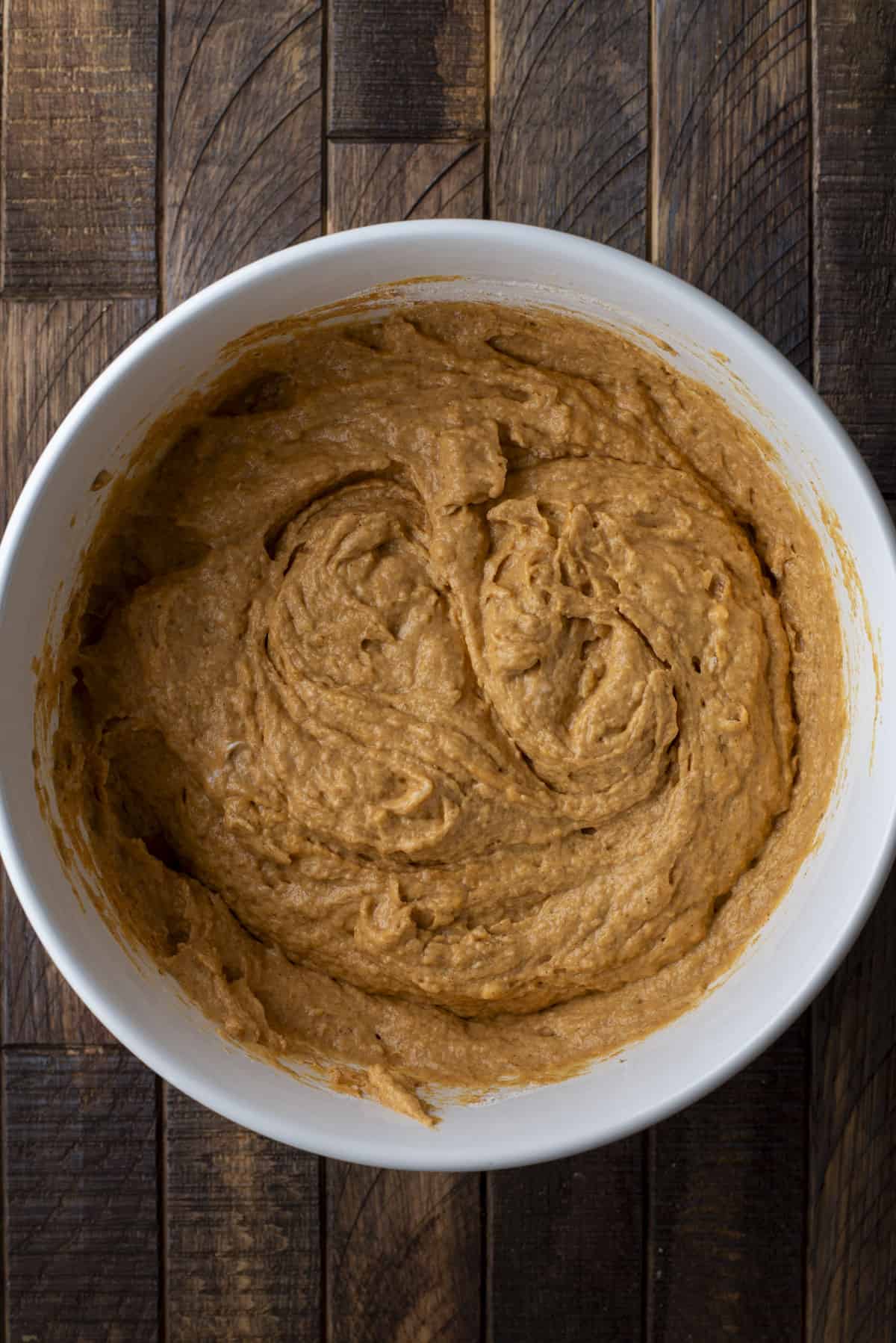 pumpkin muffin batter mixed in a large white bowl