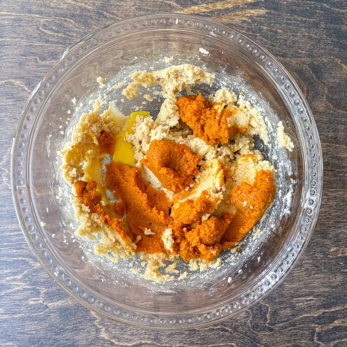 pumpkin puree and other cookie dough ingredients in a clear glass bowl