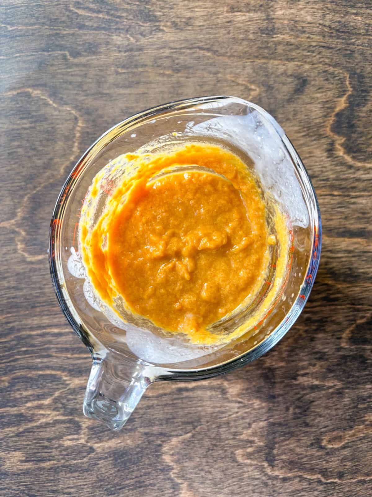 over head view of a pumpkin puree mix in a large glass measuring cup