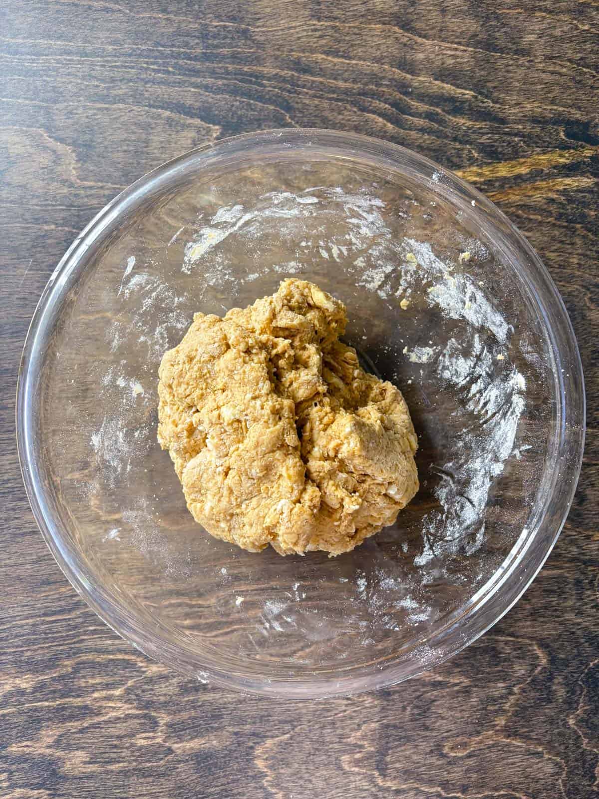 over head view of pumpkin scone dough in a clear glass bowl