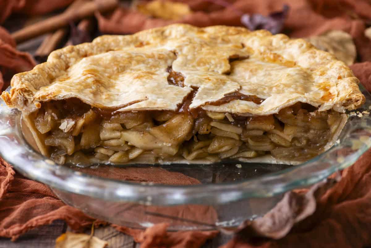 half an apple pie in a pie dish, showing the inside of the pie filling