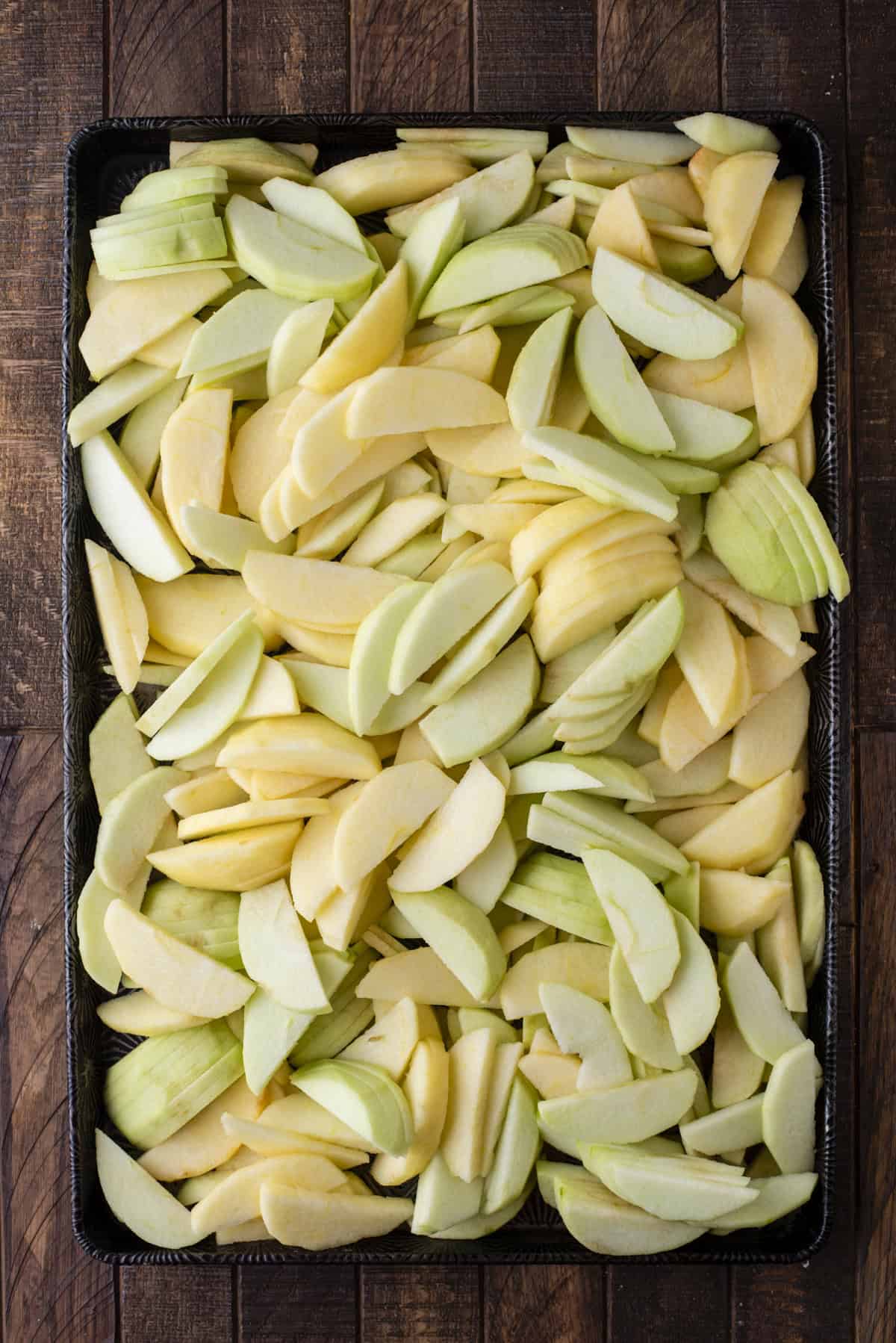 over head view of apple slices spread over a baking sheet