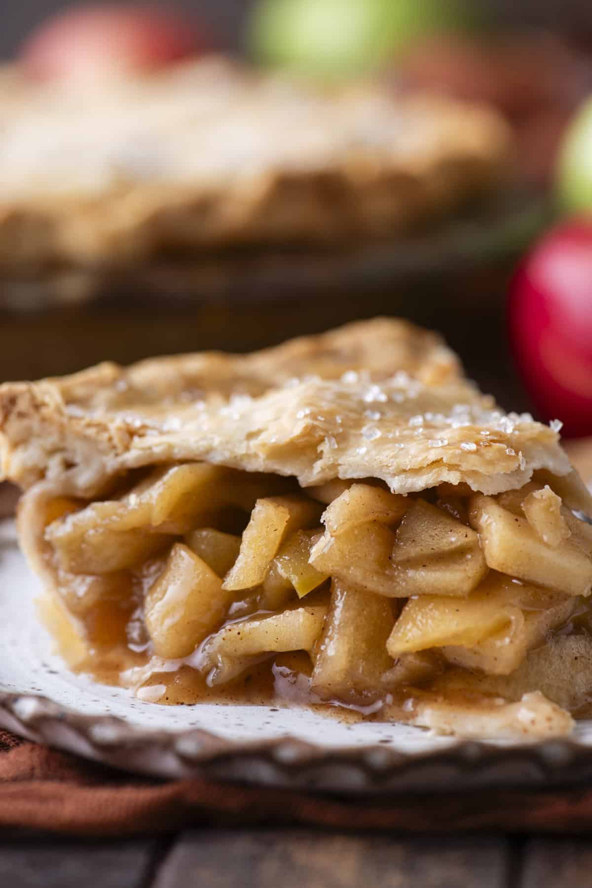 side view of a slice of apple pie on a small white plate