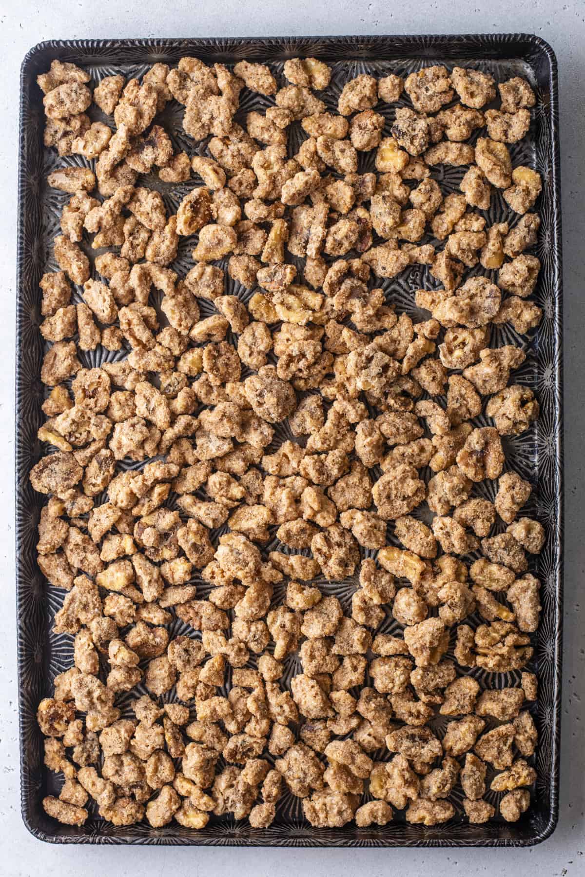 candied walnuts spread out over a baking sheet