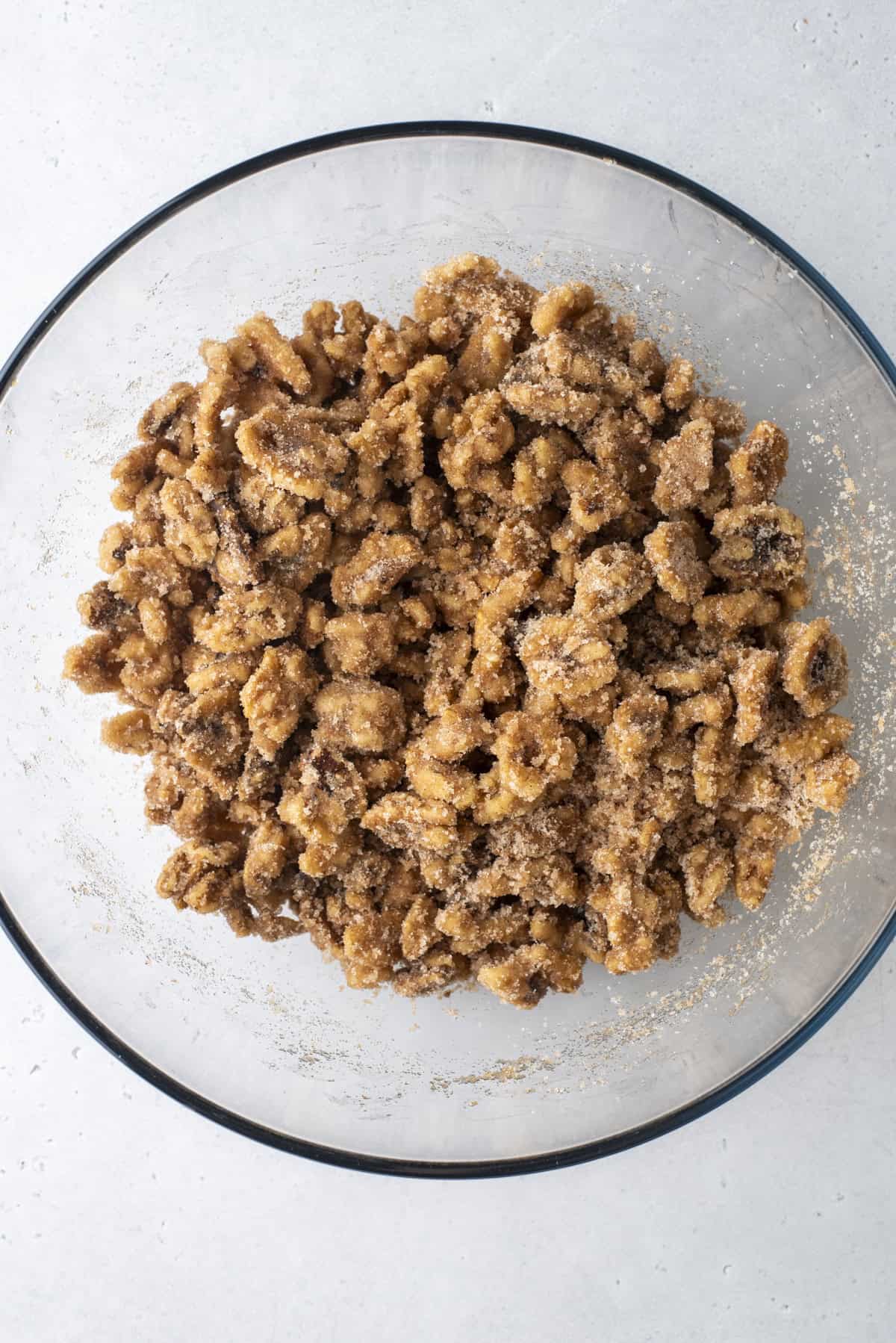 walnuts coated in a cinnamon sugar mixture in a glass bowl