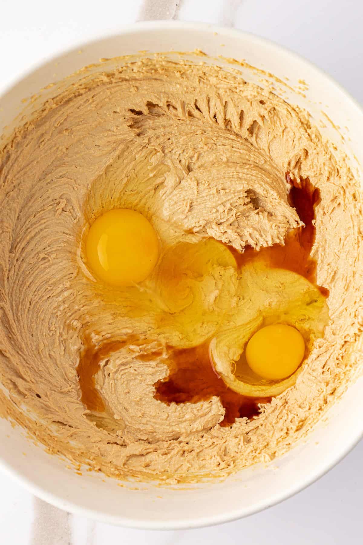 over head view of peanut butter oatmeal cookie dough ingredients in a large white bowl