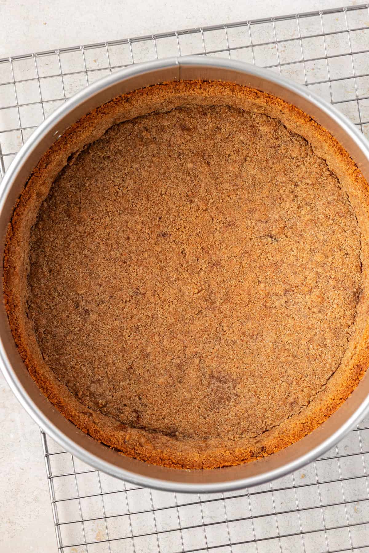 graham cracker crust in a springform pan on top of a wire rack