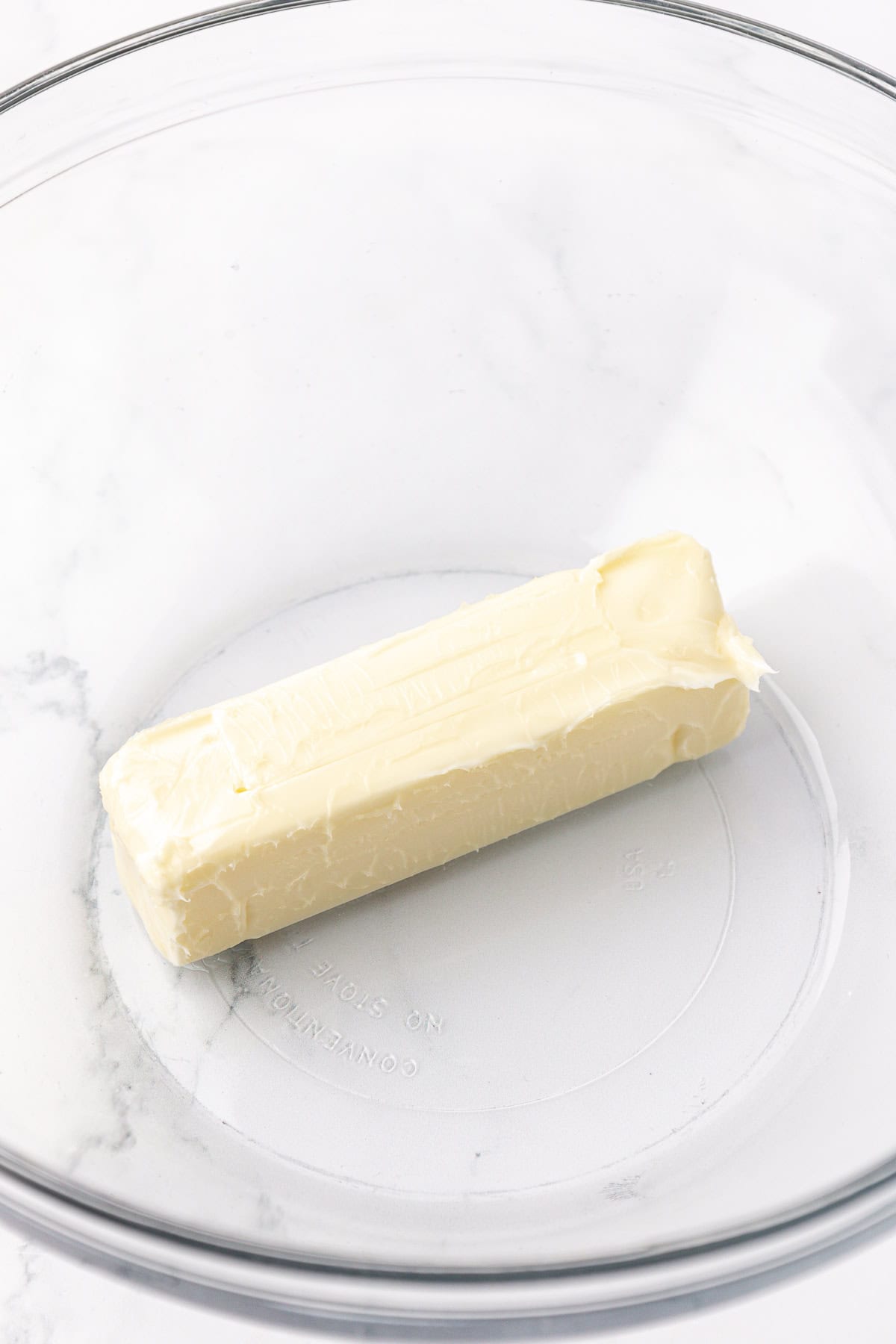 a stick of butter in a clear glass bowl