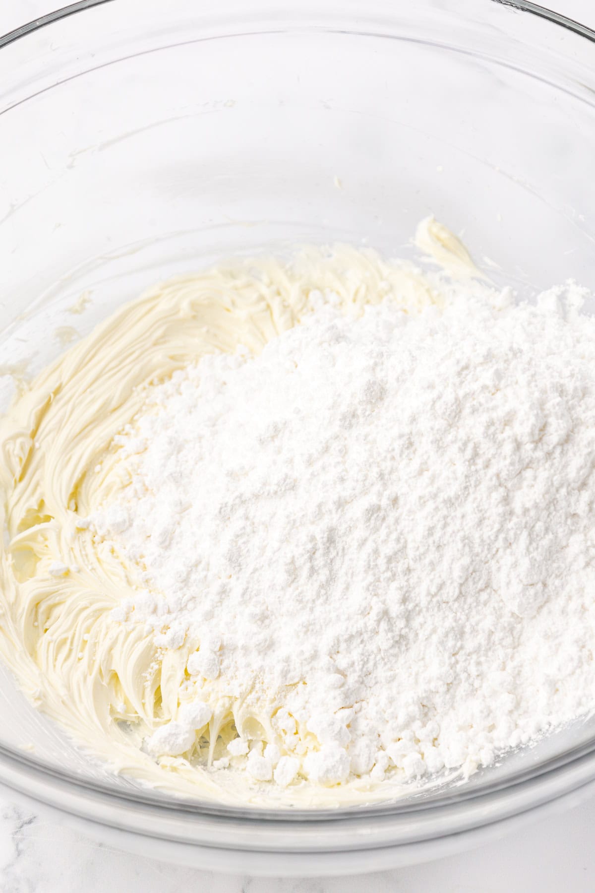 ingredients for butter mints in a clear glass bowl not yet combined