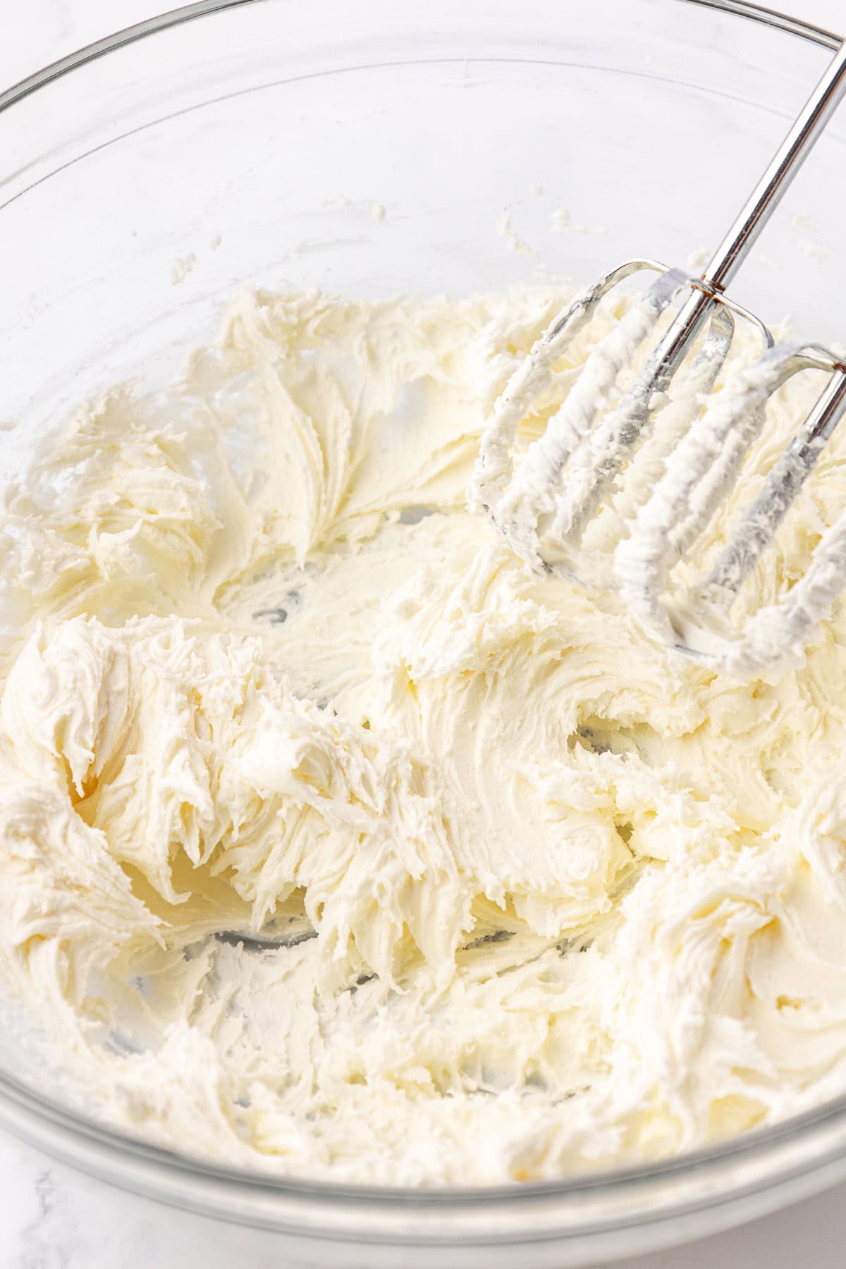 ingredients for butter mints being mixed in a clear glass bowl