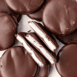 scattered and stacked peppermint patties with three halves in the middle on their sides, showing the white peppermint filling