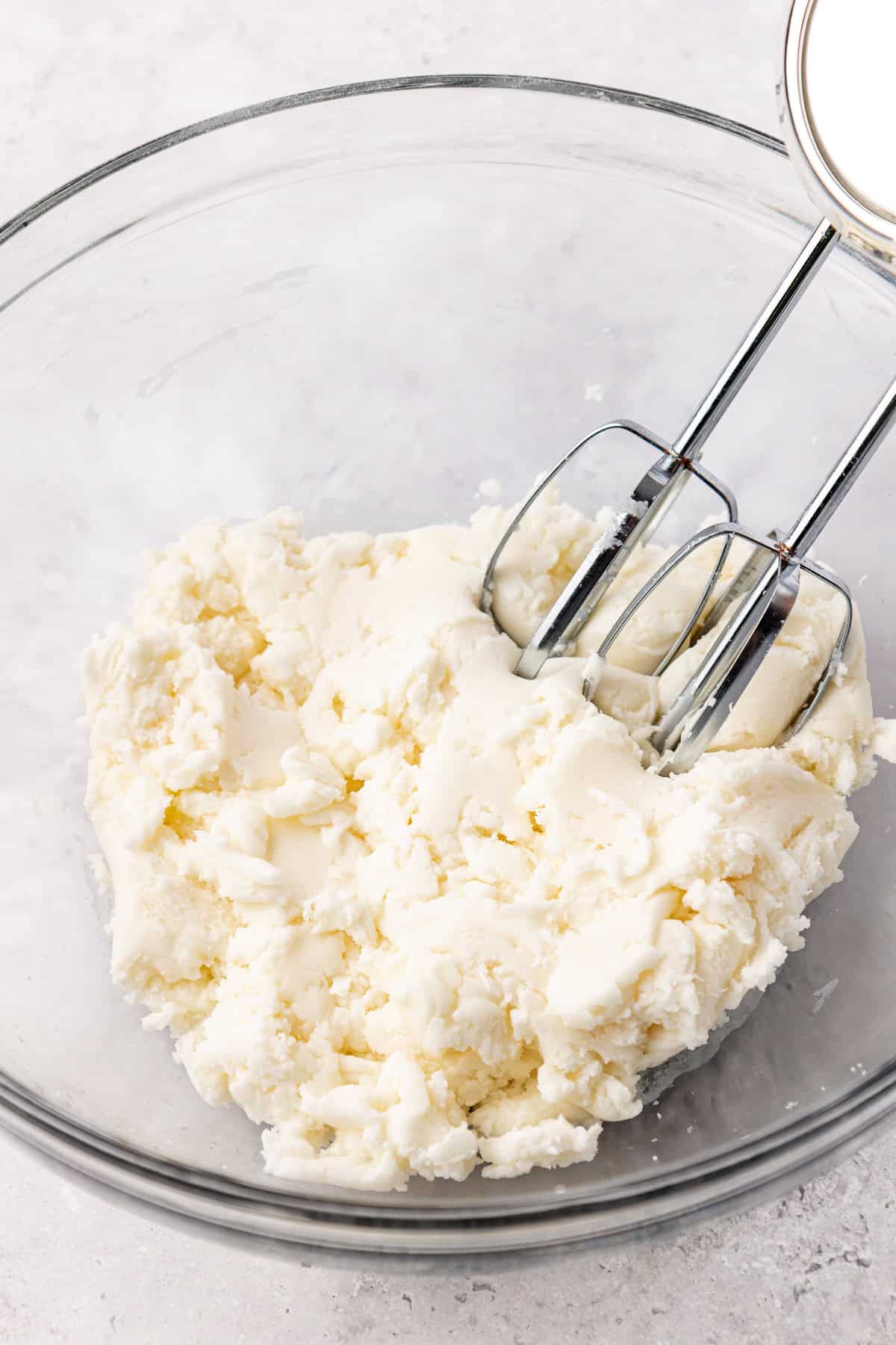 peppermint filling being mixed with an electric mixer in a clear glass bowl