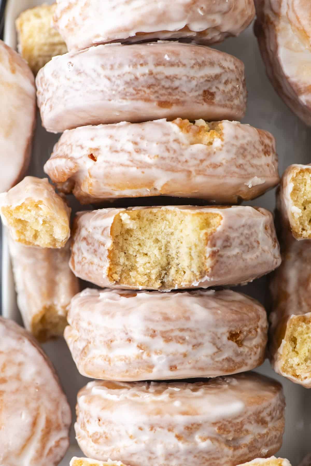 overhead view of a row of glazed donuts with pieces of donuts in between the rows