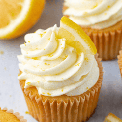 cupcakes with lemon frosting topped with fresh lemon slices and lemon zest