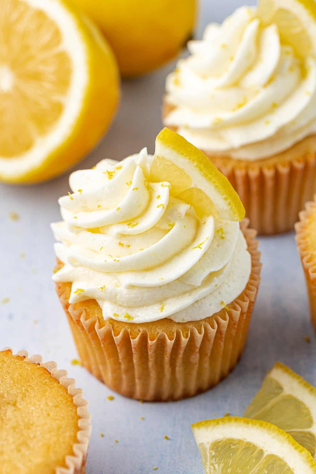 cupcakes with lemon frosting topped with fresh lemon slices and lemon zest