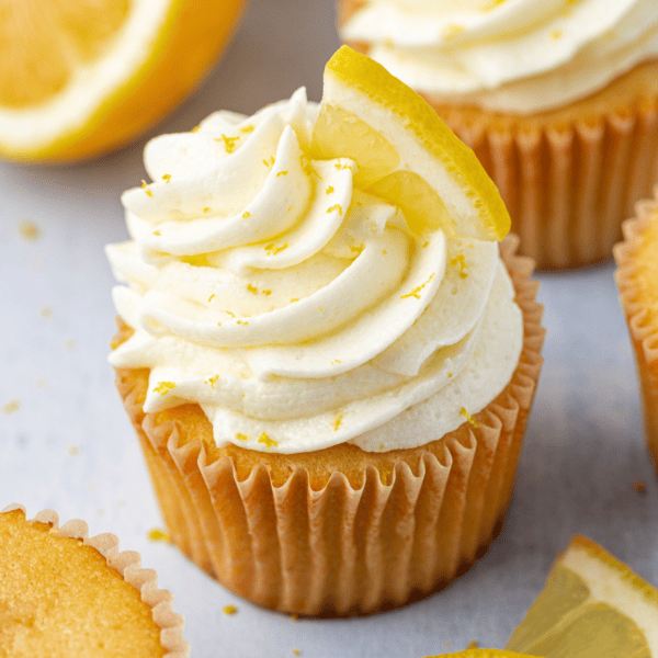 cupcakes with lemon frosting topped with fresh lemon slices and lemon zest