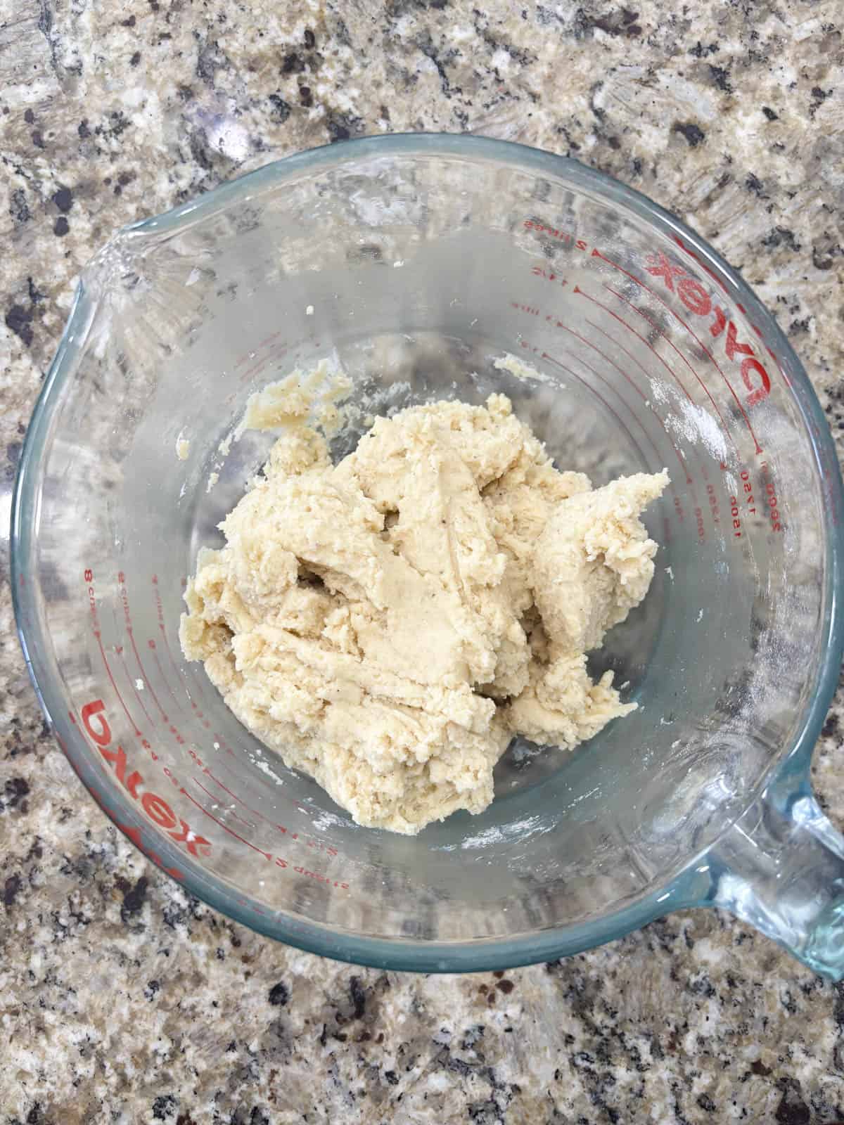 old fashioned donuts dough in a measuring cup on a countertop