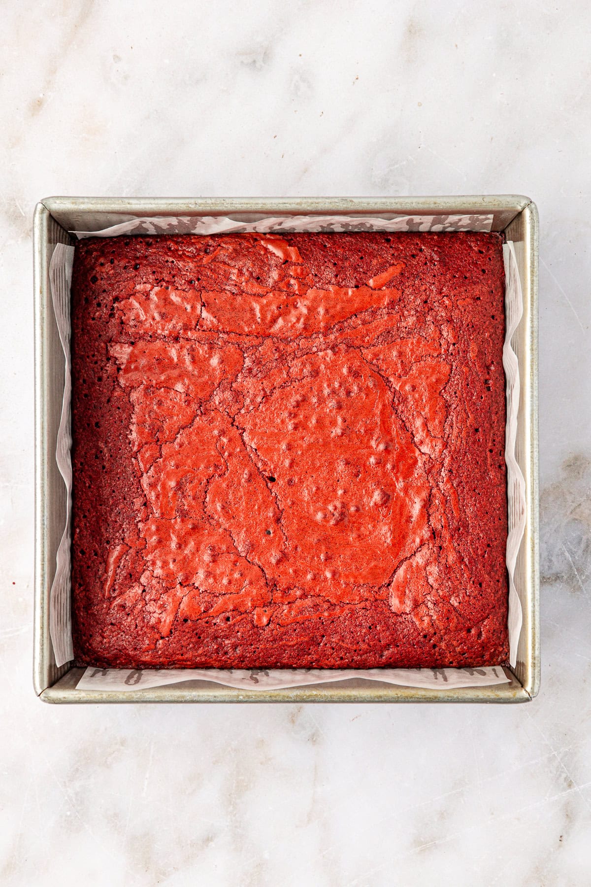 overhead view of a square baking pan full of freshly baked red velvet brownies