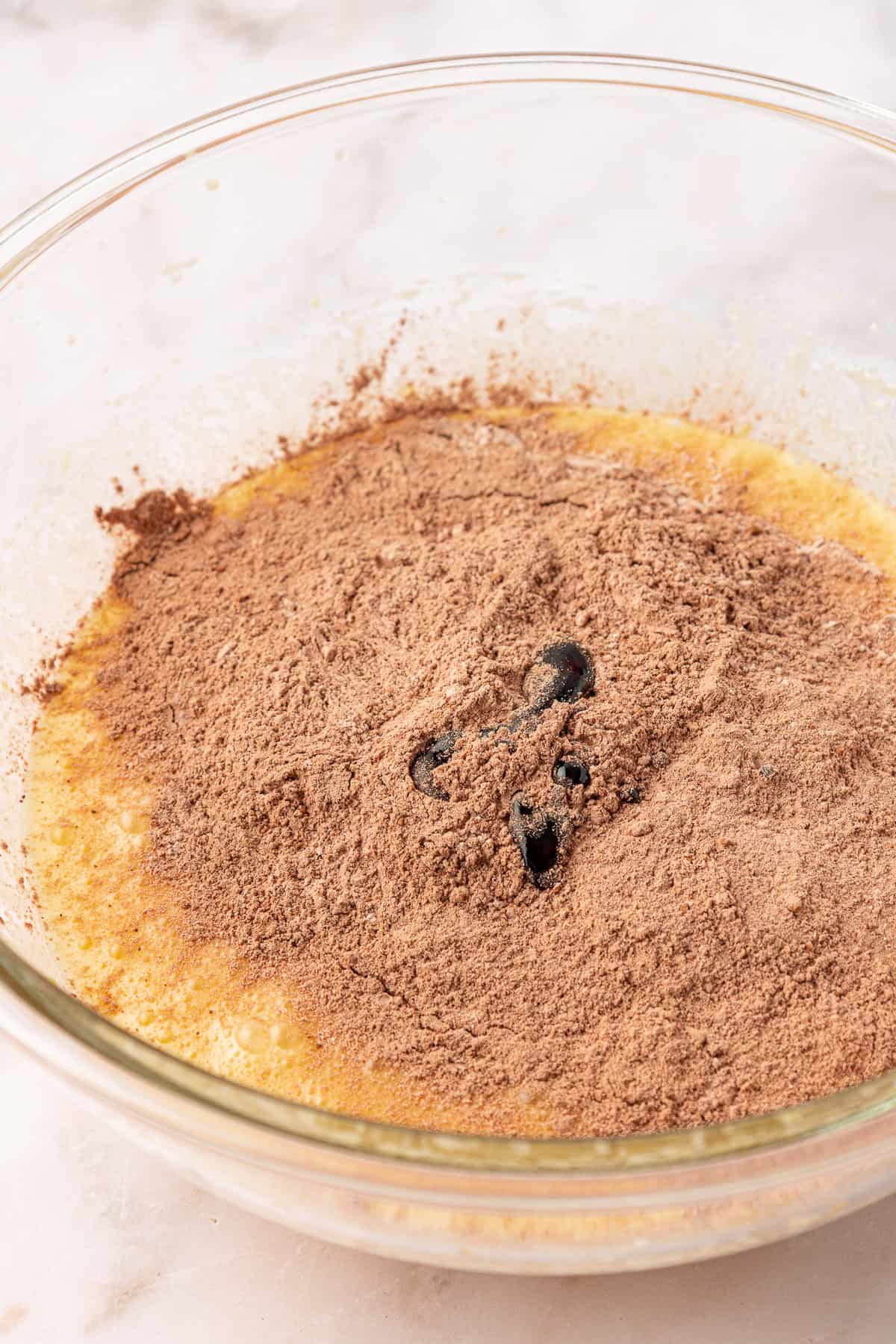 wet and dry ingredients in a clear glass mixing bowl not yet combined