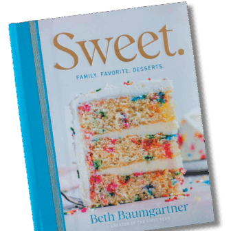 The cover of a cookbook titled Sweet. Family. Favorite. Desserts. by Beth Baumgartner features a close-up of a slice of funfetti cake with white frosting and colorful sprinkles.