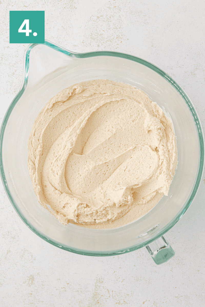 A glass mixing bowl filled with creamy, light brown batter sits on a white surface. A green box with the number 4 is in the top left corner.