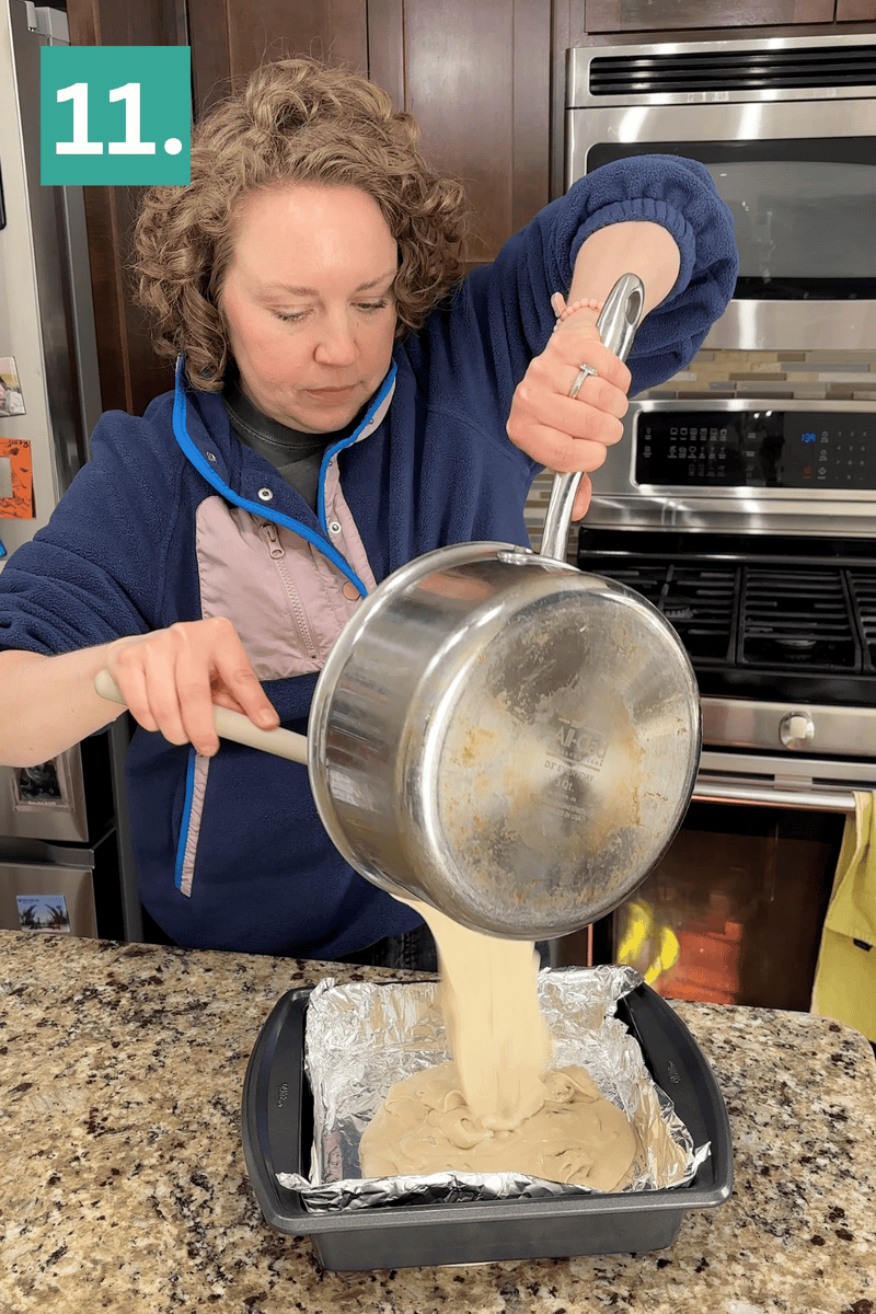 A person pours thick batter from a saucepan into a foil-lined square baking pan on a granite countertop, with the number 11 in a green box in the top left corner.