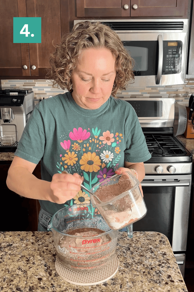 A person in a flower print shirt pours a dry ingredient mixture from one measuring cup into another in a kitchen. A green box with the number 4 is in the top left corner of the image.