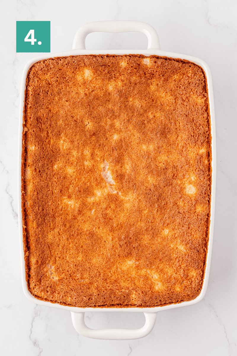 A golden-brown baked dish in a white rectangular casserole dish sits on a white marble surface. A green box with the number 4 is in the top left corner.