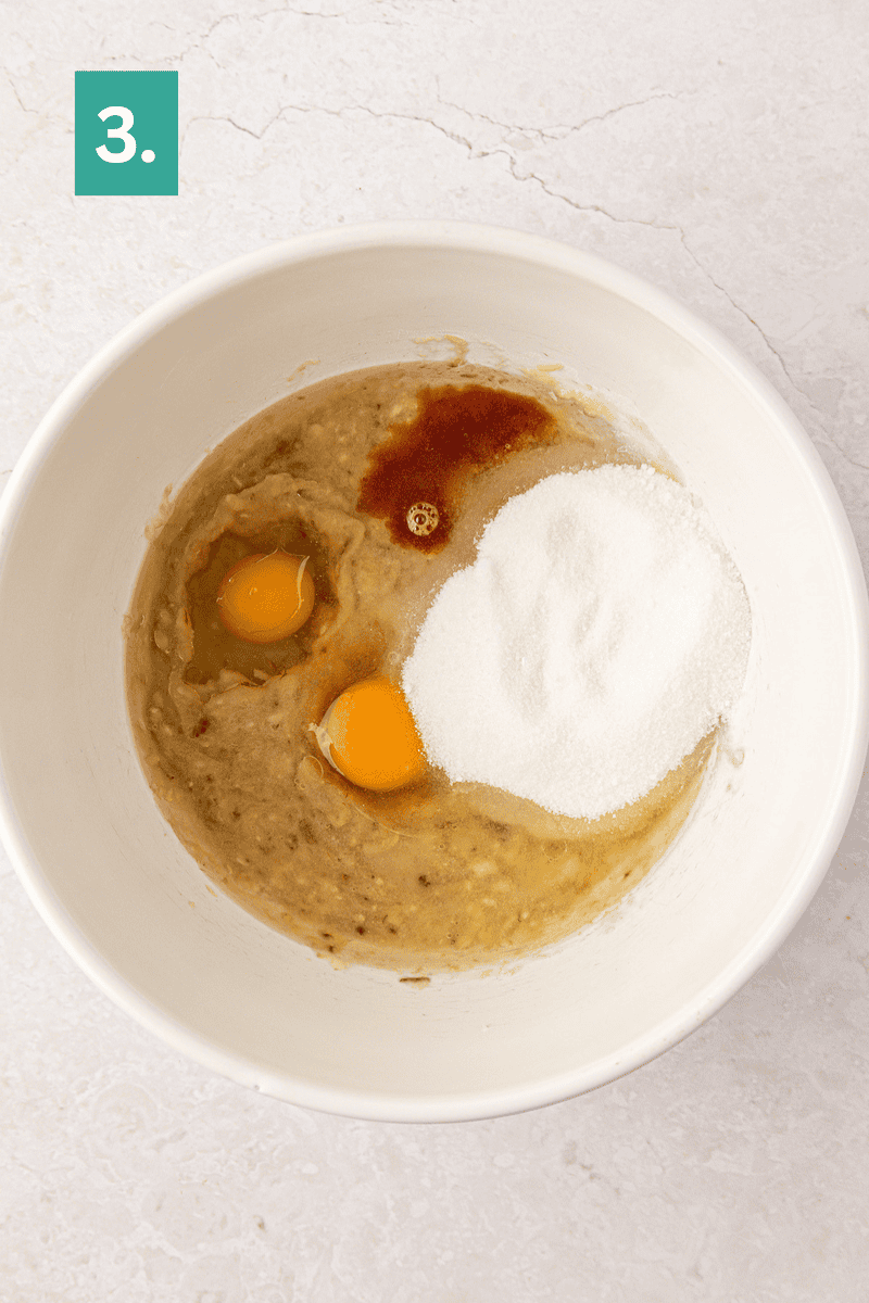 A white bowl with mashed bananas, two eggs, sugar, and vanilla extract on a light surface. A green square with 3. is in the top left corner, indicating this is step 3 of a recipe.