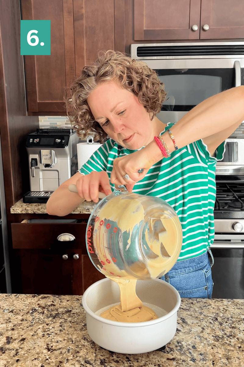 A woman in a green striped shirt pours cake batter from a glass bowl into a round cake pan in a kitchen. A step number “6.” appears in the top left corner.