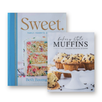 Two cookbooks side-by-side: Sweet. featuring a funfetti layer cake, and Bakery Style Muffins featuring chocolate chip muffins on a cake stand.